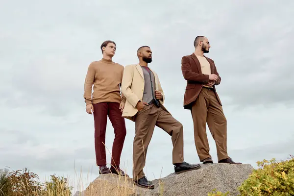Handsome male models showcasing fashionable autumn attire stand confidently in a vibrant field. — Stock Photo