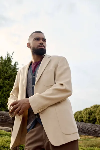 An elegantly dressed man enjoys an autumn day, blending fashion with the beauty of nature around him. — Stock Photo