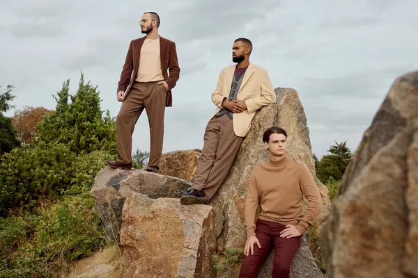 Three handsome men pose confidently in a picturesque field during the vibrant autumn season. — Stock Photo