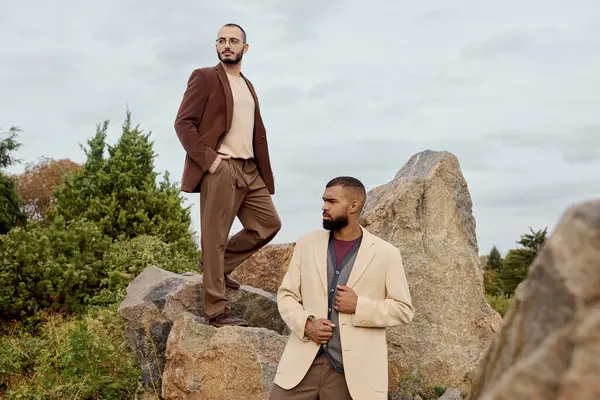 Handsome men pose confidently in stylish autumn outfits against a vibrant natural backdrop. — Stock Photo