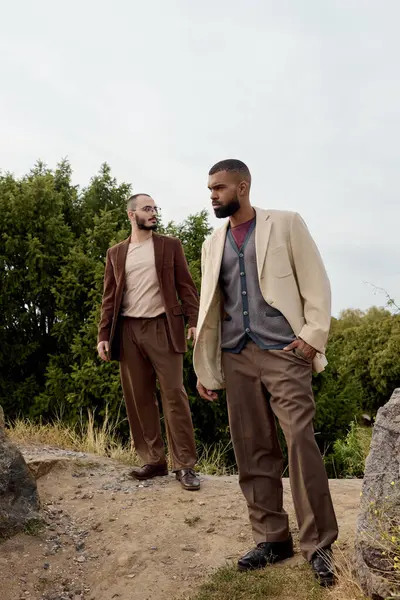 Deux beaux hommes posent élégamment en tenue d'automne, entourés de couleurs vives nature. — Photo de stock