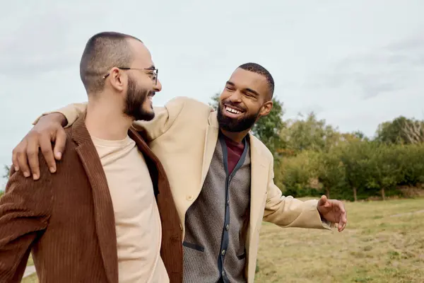 Dois homens da moda compartilham um momento alegre em um belo campo, apresentando estilo de outono e amizade. — Fotografia de Stock