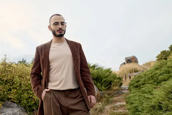 A handsome model strolls through a serene autumnal landscape, embodying seasonal style and grace. — Stock Photo