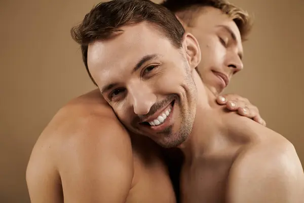 Two young men share a heartfelt embrace, showcasing love and connection in a cozy atmosphere. — Stock Photo