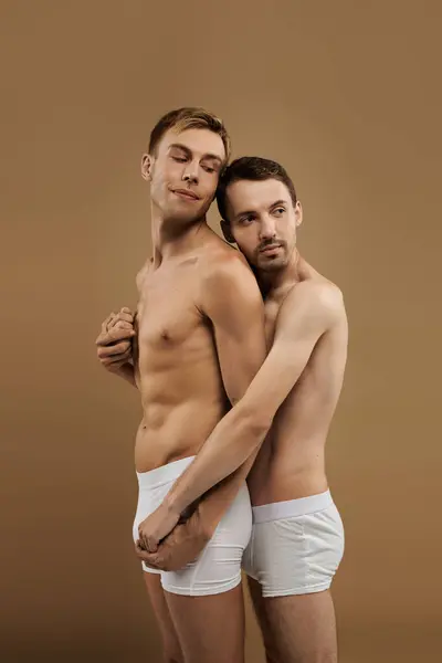 Two young men share a heartfelt embrace, radiating love and connection in a cozy setting. — Stock Photo