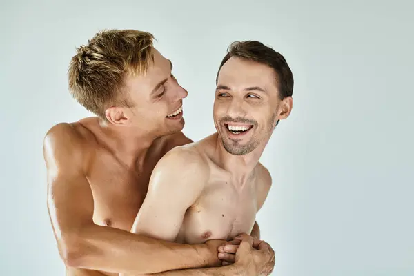 Dois jovens compartilham um abraço alegre, rindo e desfrutando de seu tempo juntos no calor. — Fotografia de Stock