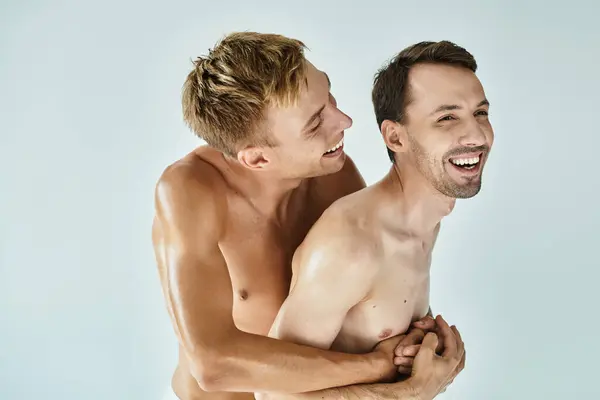 Zwei junge Männer teilen einen herzlichen Moment, umarmen sich und lachen fröhlich miteinander. — Stockfoto