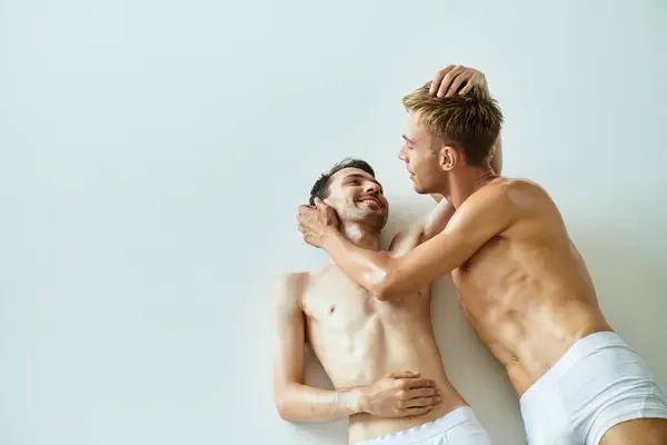 Two young men express their affection, enjoying a cozy moment together in a bright setting. — Stock Photo