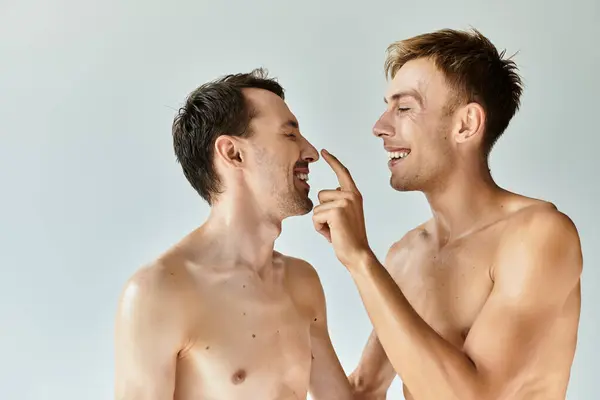 Zwei junge Männer teilen einen entzückenden Moment und umarmen Liebe und Verbindung mit freudigem Lächeln. — Stockfoto