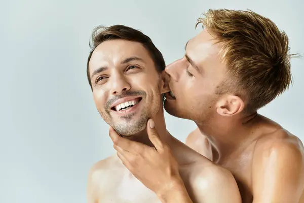 Dos jóvenes expresan afecto, disfrutando de una íntima y lúdica conexión juntos. - foto de stock