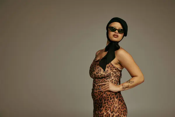 A confident young woman showcases her unique style in a striking leopard print ensemble. — Stock Photo