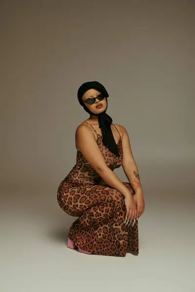 A young woman in a leopard print outfit strikes a stylish pose with confidence and grace. — Stock Photo