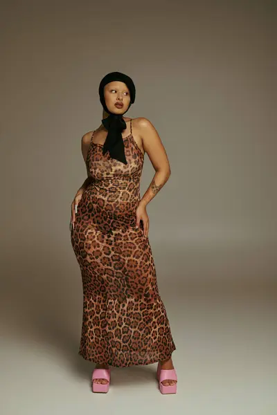 A stylish young woman poses gracefully in a trendy leopard print outfit. — Stock Photo