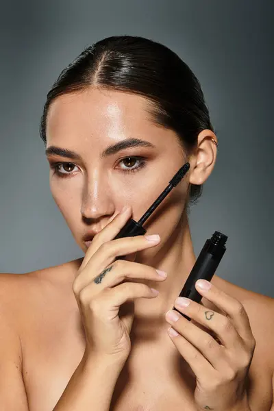 A skilled artist enhances her natural beauty using makeup tools, radiating confidence. — Stock Photo