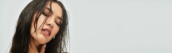A stunning young woman with wet hair showcases her beauty and confidence in a tranquil studio. — Stock Photo