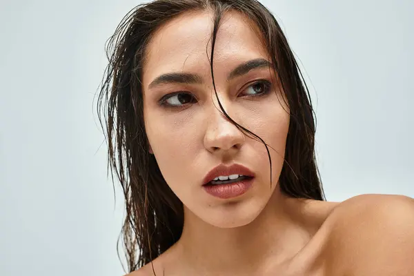 A stunning woman gazes thoughtfully with glistening wet hair and a natural expression. — Stock Photo