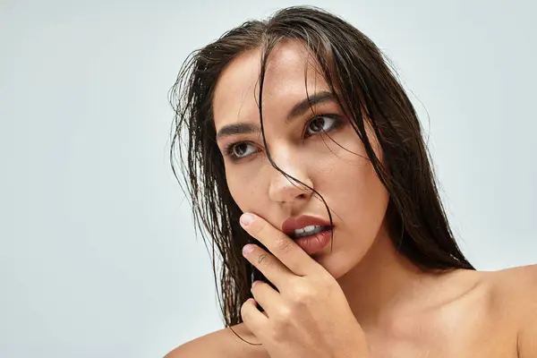 A woman with long, wet hair appears deep in thought with an expressive gaze and subtle gestures. — Stock Photo
