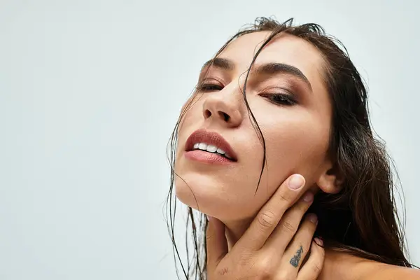 A confident woman with wet hair gently touches her neck, radiating natural beauty. — Stock Photo