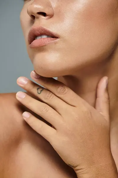 A graceful woman highlights her natural beauty while softly touching her chin, exuding confidence. — Stock Photo