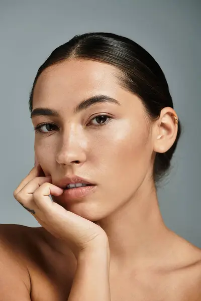 A woman poses gracefully, displaying a calm expression with soft lighting highlighting her features. — Stock Photo