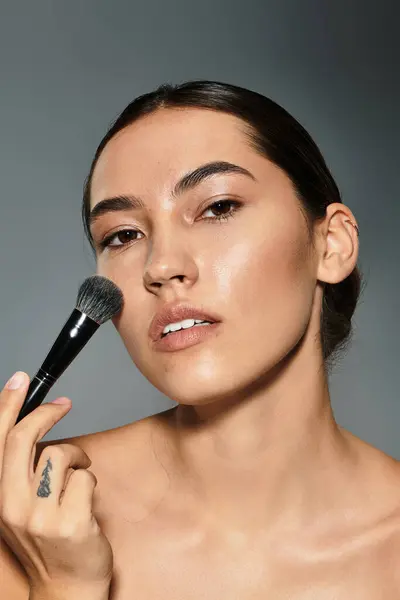 La donna applica con attenzione il trucco per migliorare la sua bellezza naturale in un ambiente creativo. — Foto stock