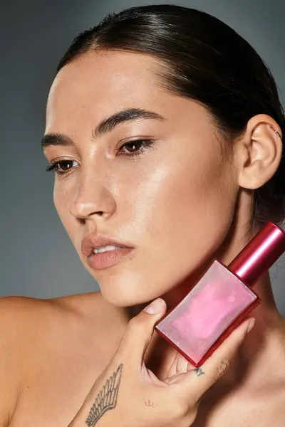 The striking subject gracefully holds a unique perfume bottle near her face, exuding confidence. — Stock Photo