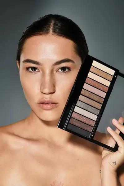 La belle femme, au look naturel, met en valeur une palette de nuances de fards à paupières chatoyantes. — Photo de stock
