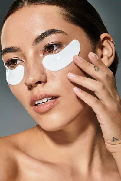 The woman applies soothing eye patches while enjoying a relaxing moment dedicated to self care. — Stock Photo