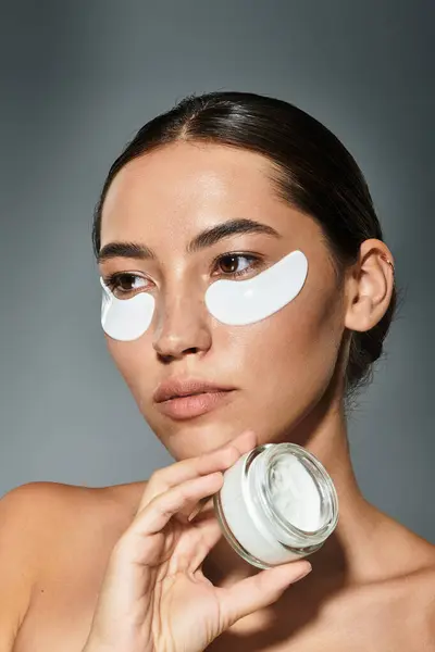 In a calming atmosphere, a beautiful woman focuses on her skincare ritual, highlighting self care. — Stock Photo