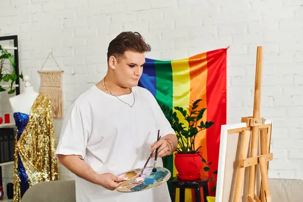 An artistic individual explores their creativity with a paint palette in a colorful studio setting. — Stock Photo