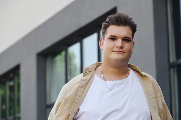 A queer person exudes confidence while walking along a stylish cityscape in daylight. — Stock Photo
