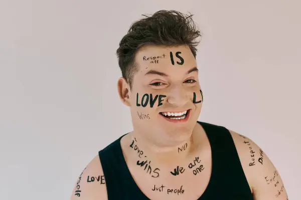 A joyful queer individual showcases expressive body art with uplifting messages written all over. — Stock Photo