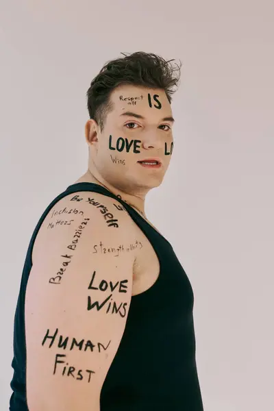 A queer individual confidently showcases powerful messages of love and acceptance on their body. — Stock Photo