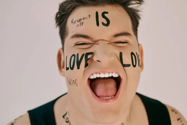 An energetic person joyfully shouts while showcasing words of love painted on their face. — Stock Photo