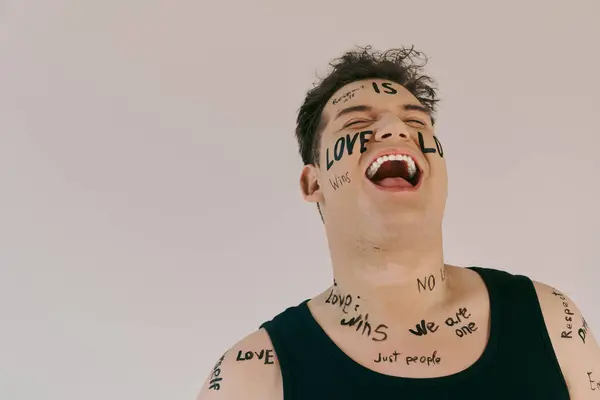 Eine queere Person zeigt freudig Körperkunst, die Liebe und Einheit während einer kreativen Sitzung feiert. — Stockfoto