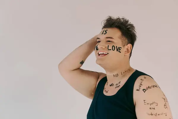 Ein fröhliches Individuum drückt Identität und Liebe durch kraftvolle Worte aus, die über ihren Körper geschrieben werden. — Stockfoto