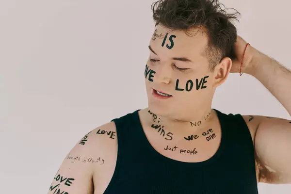 An appealing queer person showcases creativity with body art featuring powerful affirmations. — Stock Photo