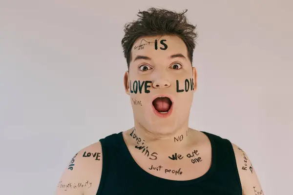 A queer person in a sleeveless top exudes confidence with words of love on their skin. — Stock Photo