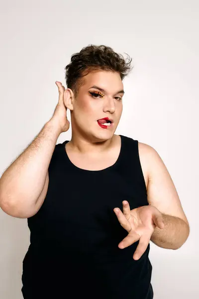 A person embraces their beauty with bold makeup and confident posture in creative styling. — Stock Photo