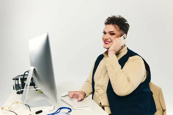 This vibrant person is smiling and talking on the phone while focused on their work. — Stock Photo
