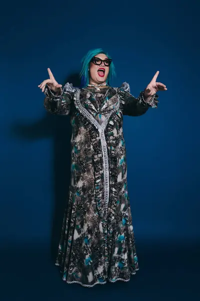 An expressive person with striking blue hair showcases their unique attire with enthusiasm and joy. — Stock Photo