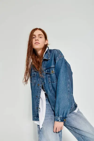 Un adolescent met en valeur son style unique dans une tenue en denim tout en posant dans un studio contemporain. — Photo de stock