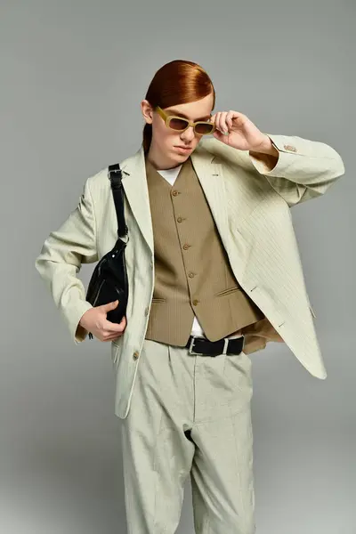 A teenage boy with striking red hair showcases an elegant smart casual outfit in a minimalist grey setting. — Stock Photo