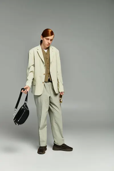 A teenage boy with distinctive red hair poses confidently in an elegant smart casual outfit within a grey studio. — Stock Photo