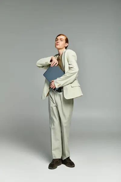 A teenage boy with vibrant red hair confidently showcases a chic outfit in a contemporary studio backdrop. — Stock Photo