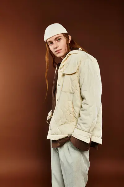 A teenage boy with striking red hair showcases trendy attire against a warm backdrop. — Stock Photo