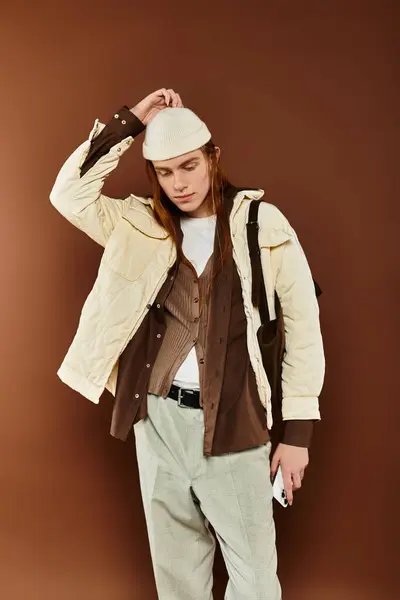 A teenage boy with striking red hair dons trendy attire, showcasing a confident pose in a warm studio. — Stock Photo