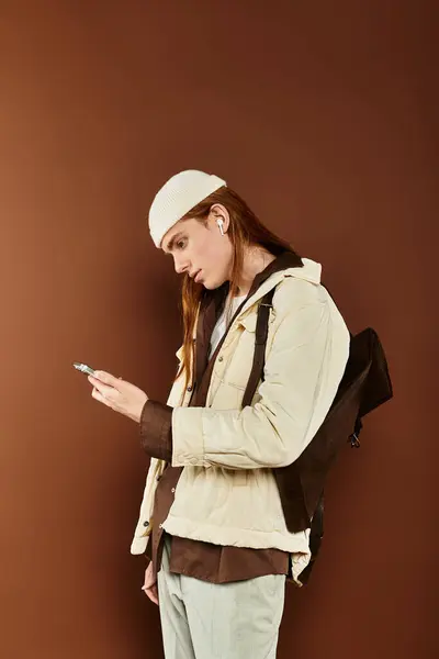 A teenage boy with striking red hair stands confidently, dressed stylishly while checking his phone. — Stock Photo
