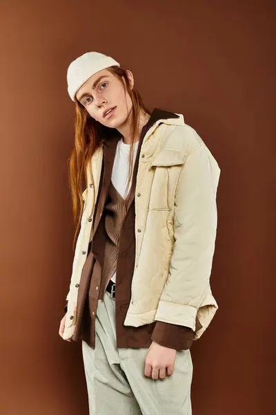 A teenage boy with vibrant red hair stands confidently in fashionable clothing within a chic studio backdrop. — Stock Photo