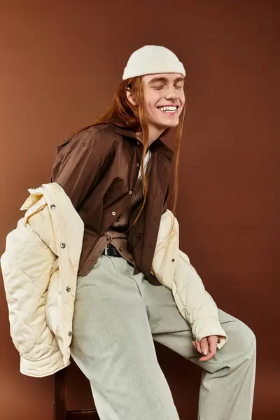 A teenage boy with striking red hair showcases a fashionable outfit while posing in a studio. — Stock Photo
